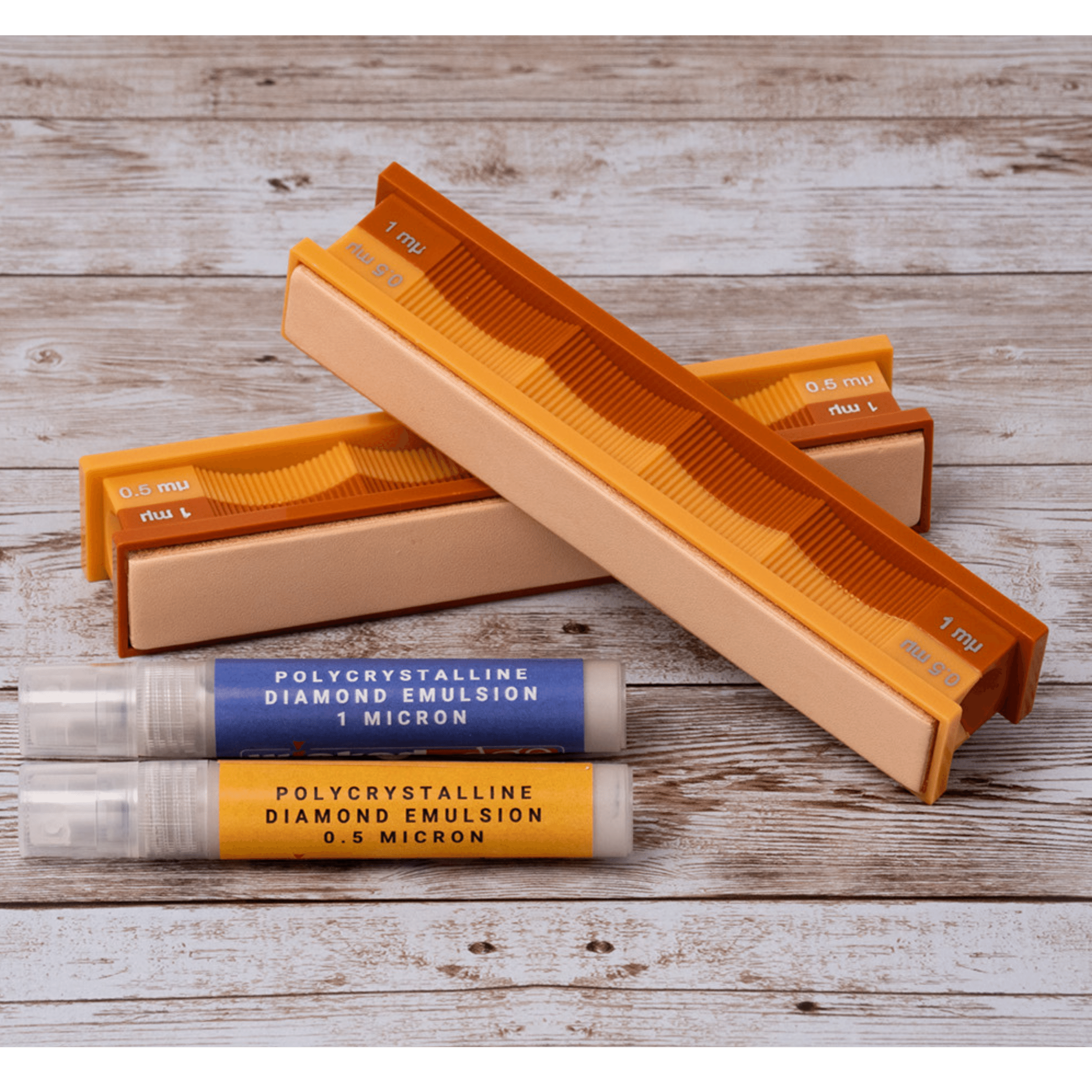 1/0.5 micron diamond emulsion and leather strops pack in studio lighting at close-up from top-down angle.