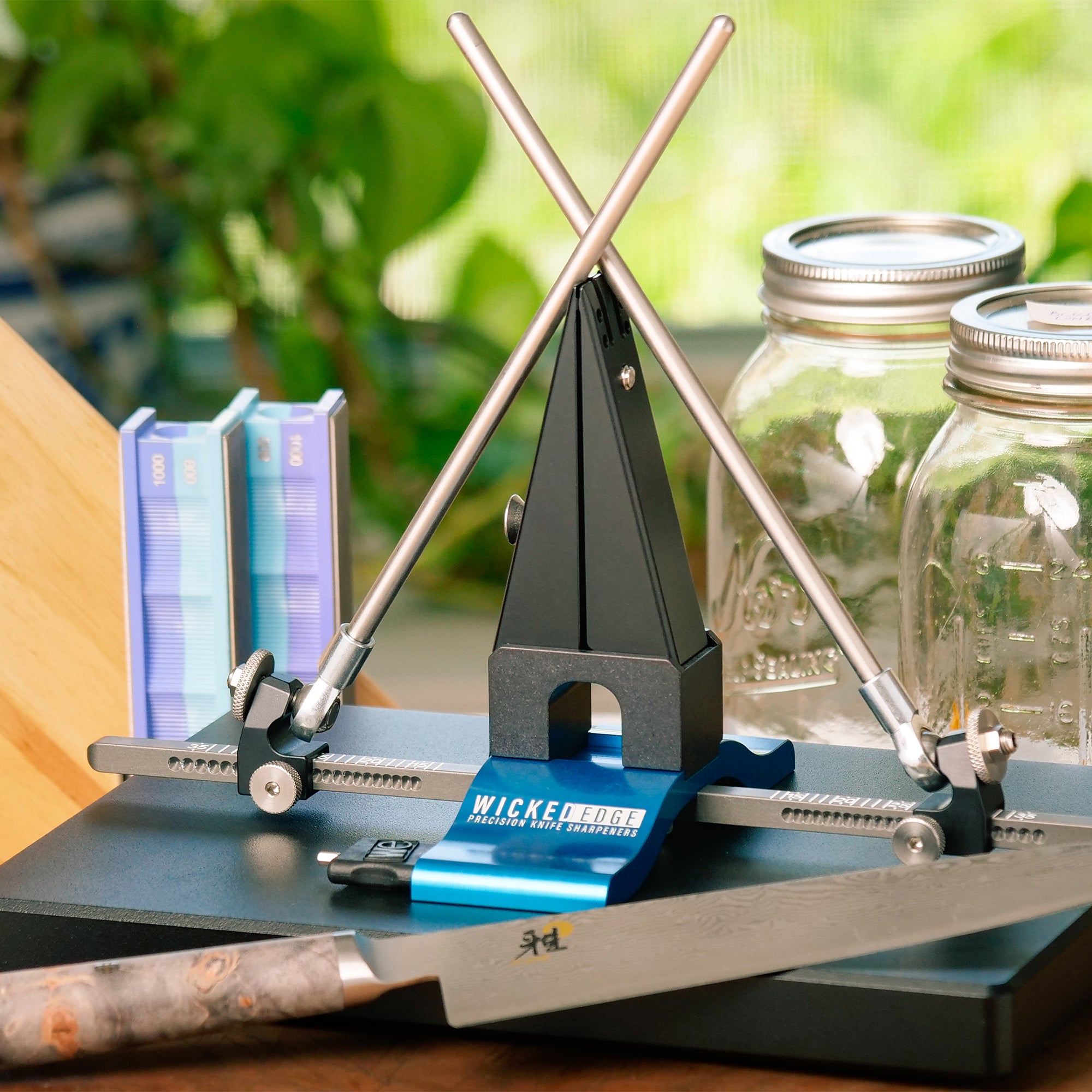 Wicked Edge Precision Sharpener WE120 dual-sided knife sharpener on table with accessories at close-up from front angle.