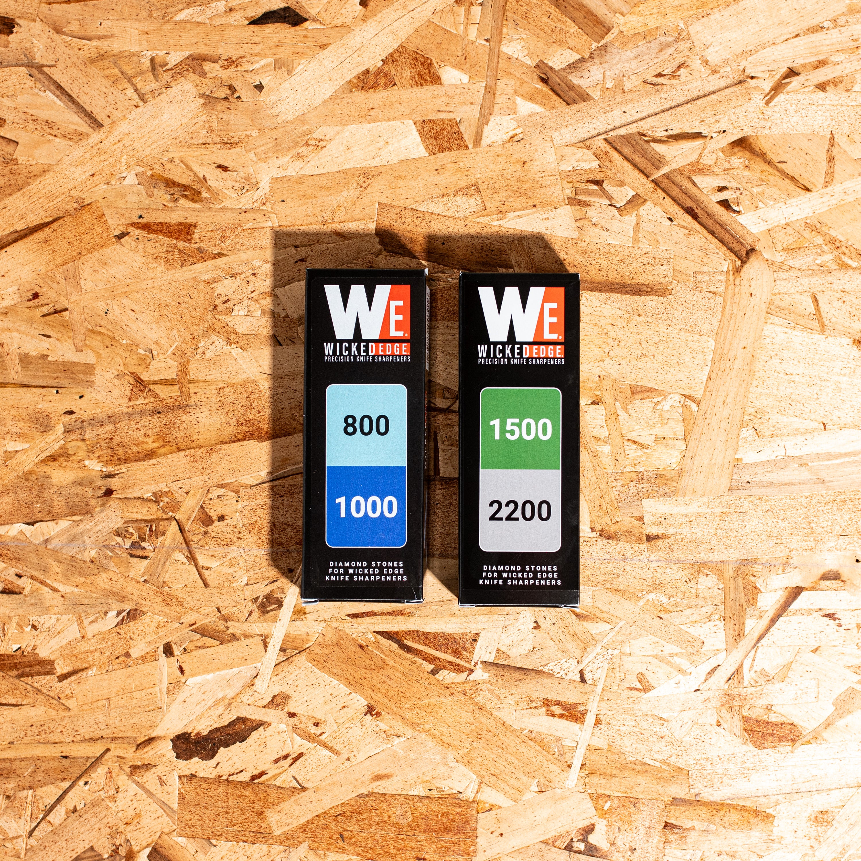 Edge Kit I (EDC/Kitchen) diamond sharpening stones in close-up on wood shavings at high zoom from front angle.