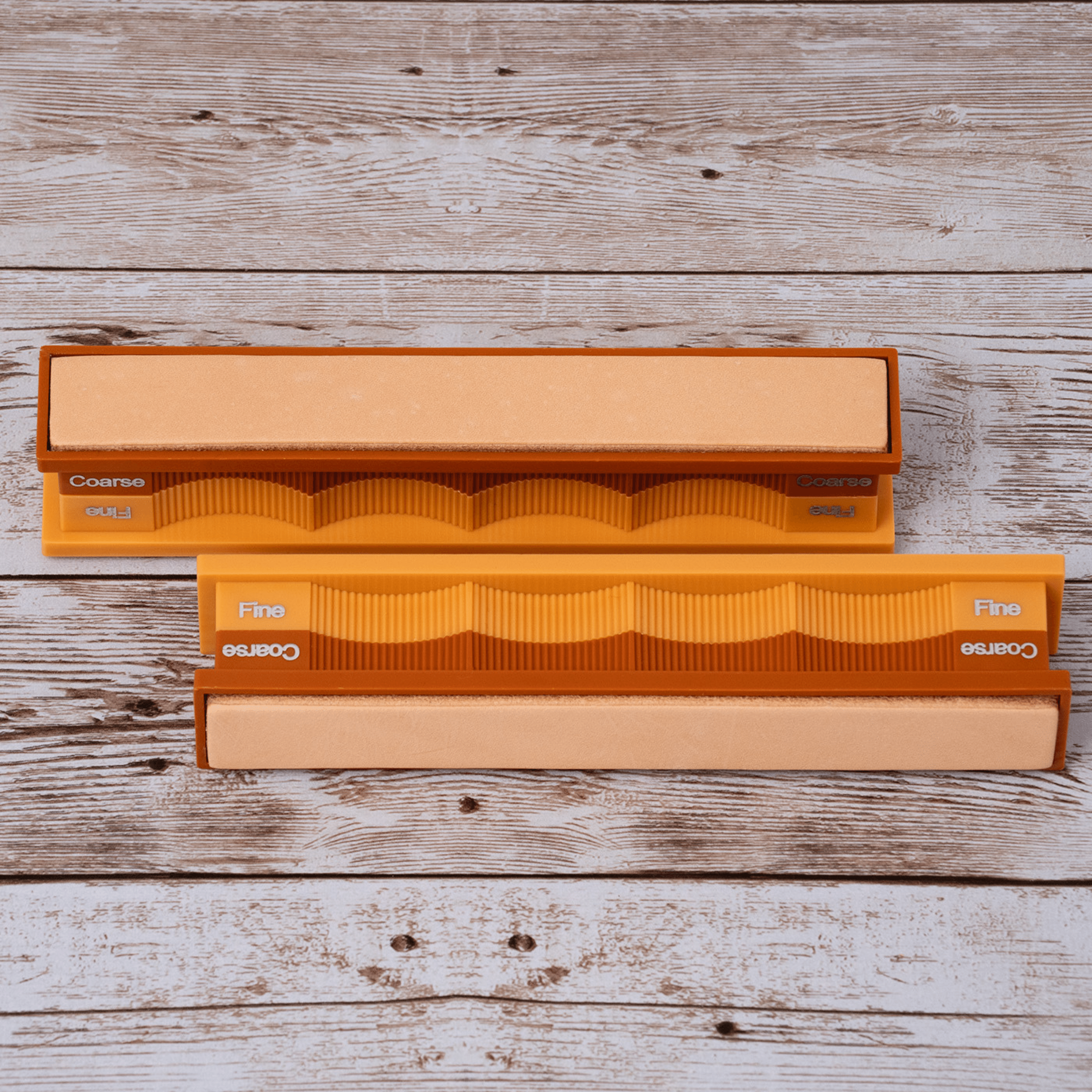 Blank leather strops pack in open case on weathered wood surface at close-up zoom from above.