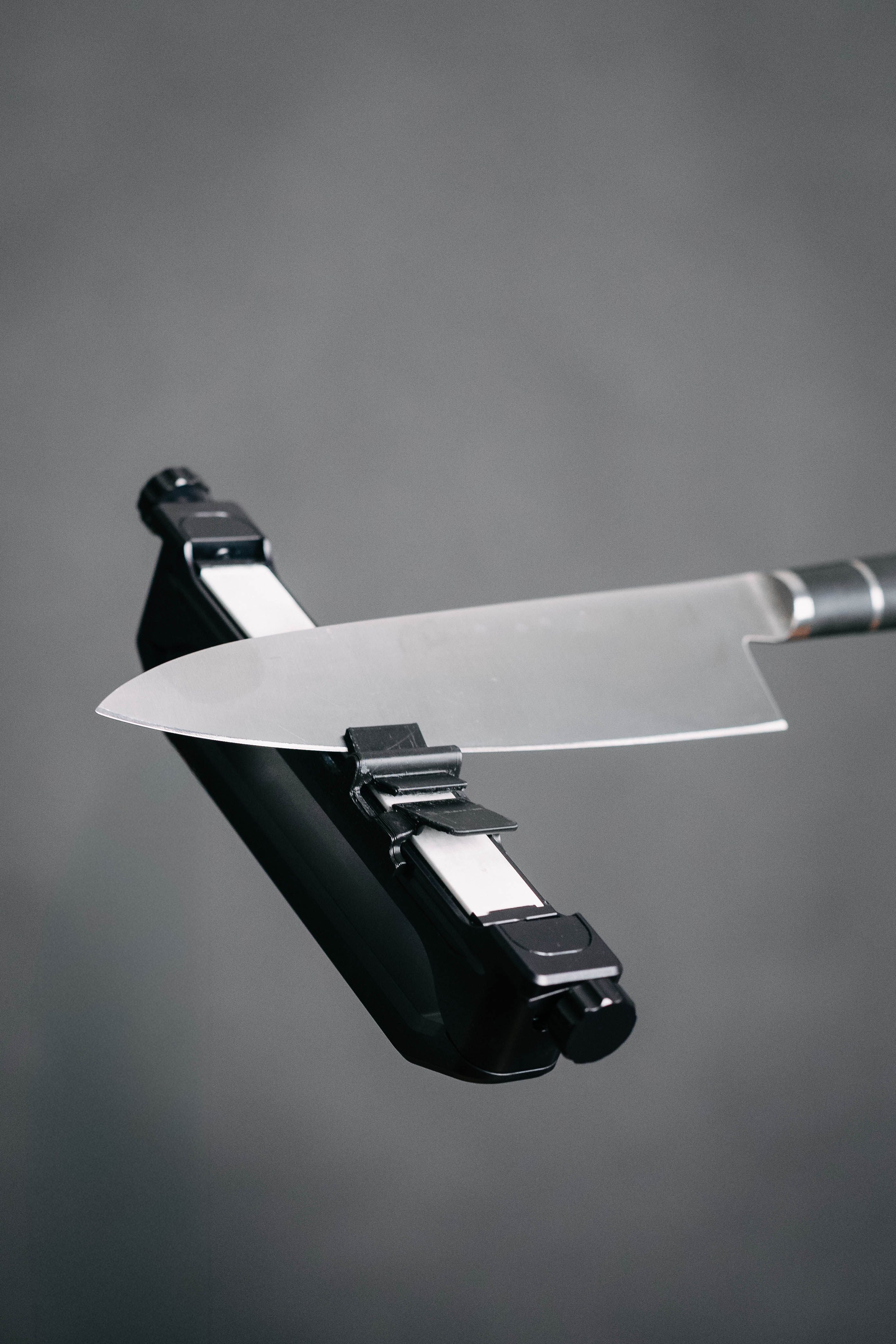 A chefs knife being sharpened in the Venture Pro portable precision knife sharpener