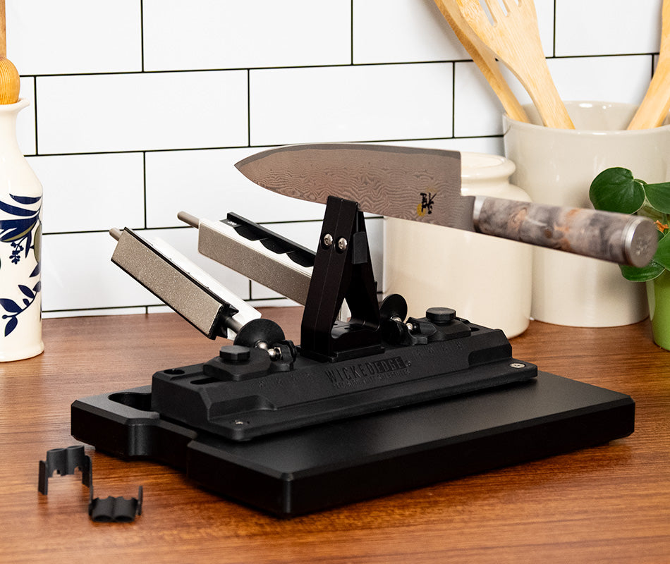 Wicked Edge WE40 dual-sided knife sharpener in kitchen setting at close-up from front angle.