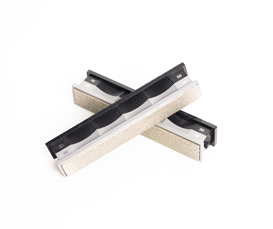 Premium 50/80 Grit Diamond Stones Pack sharpening stones crossed on white background at close-up zoom from top-down angle.