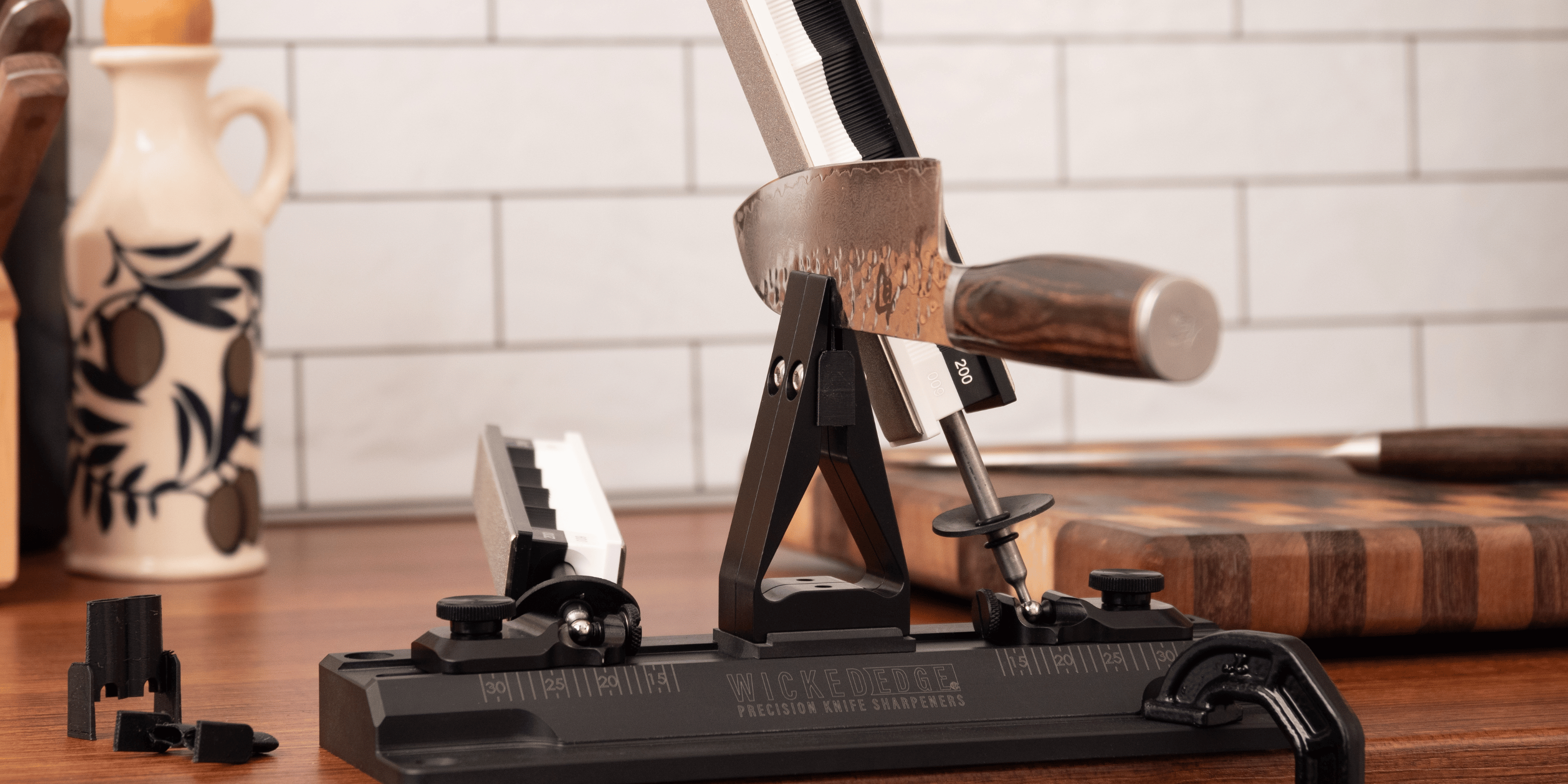 WE40 Carbon precision knife sharpener with chef's knife mounted in vise. Front view.