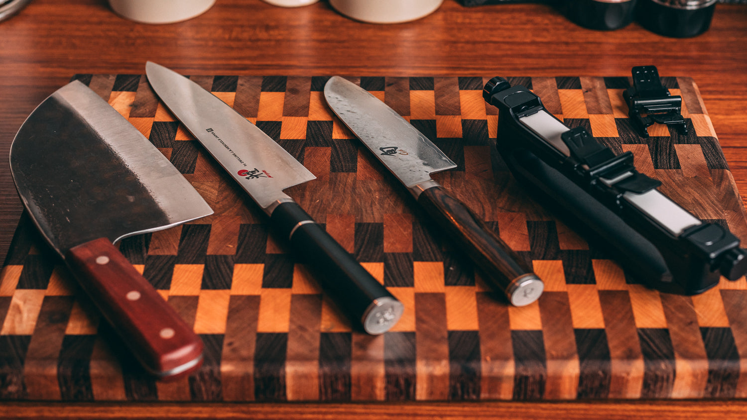 Set of knives on a wooden cutting board with a checkered pattern
